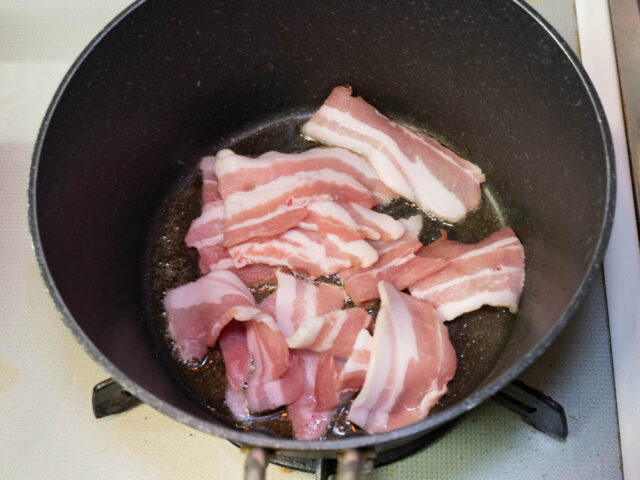 鍋にごま油を熱して、豚肉を加えた写真