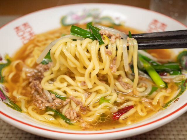 麺ともやしとニラを箸で持ち上げた写真