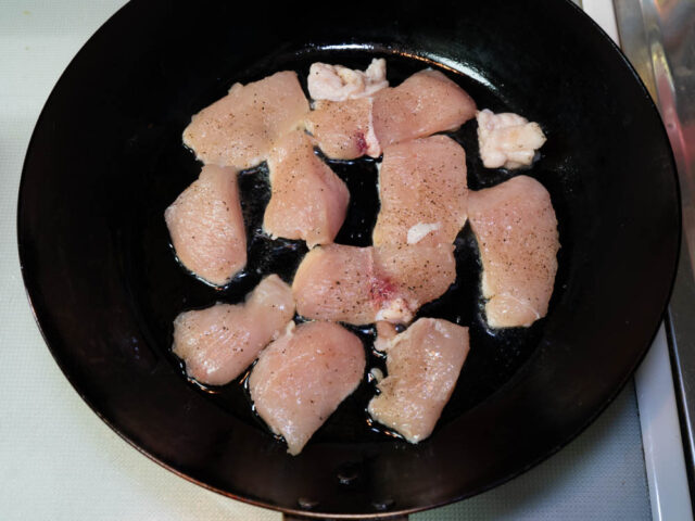 フライパンにごま油を熱して、鶏胸肉を並べ入れた写真