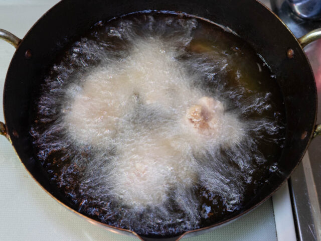 油の中に鶏肉を入れた写真