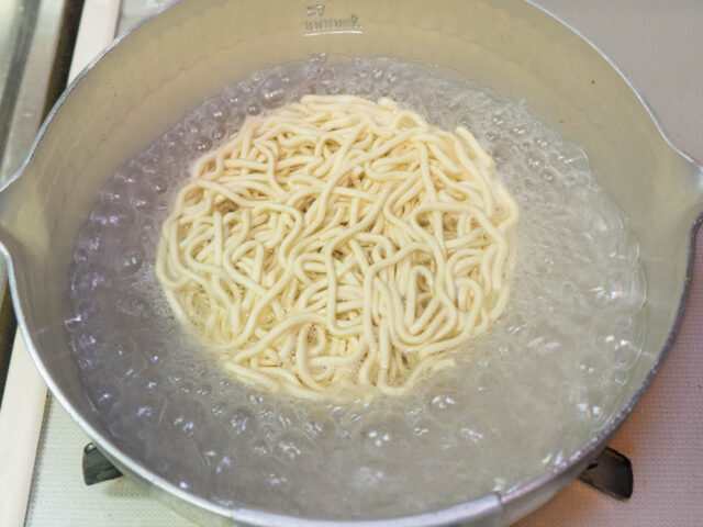 鍋にお湯を沸かしてインスタント麺を入れた写真