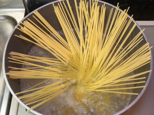 鍋にお湯を沸かしてパスタを入れた写真