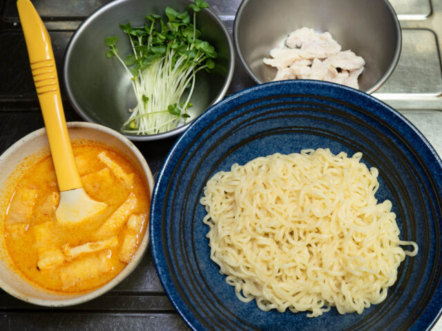 丼入れた麺、スープ、かいわれ、サラダチキンを並べた写真
