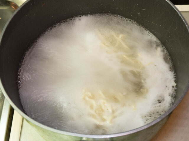 鍋にお湯を沸かして中華麺を茹でる写真