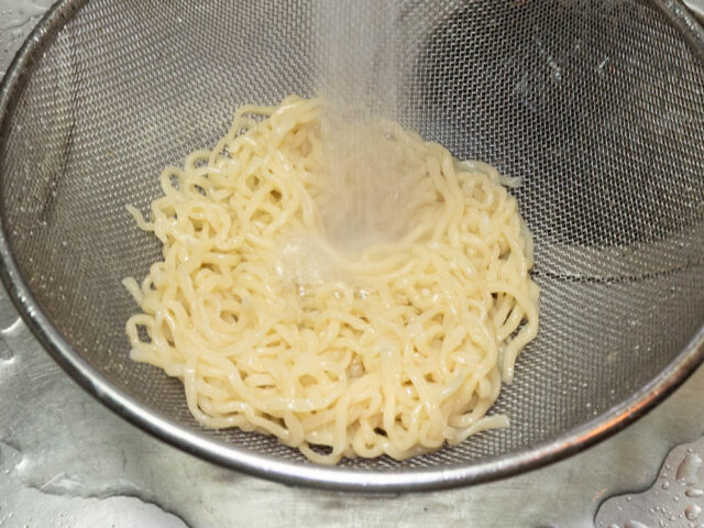 茹でた麺に流水を当てる写真
