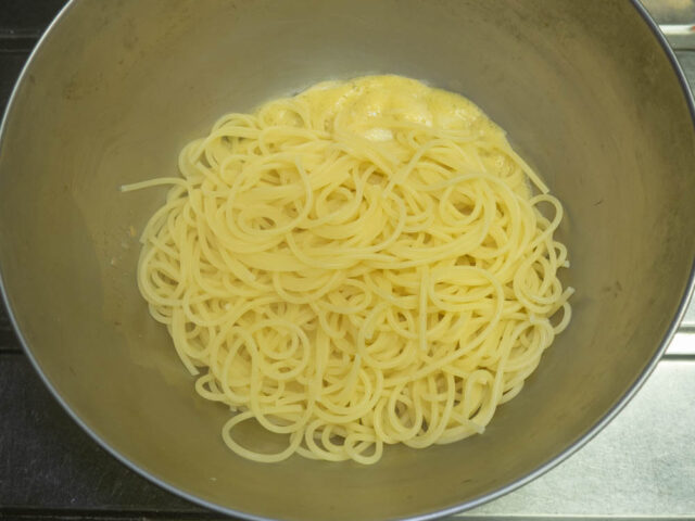 茹で上がったパスタをソースのボウルに入れた写真