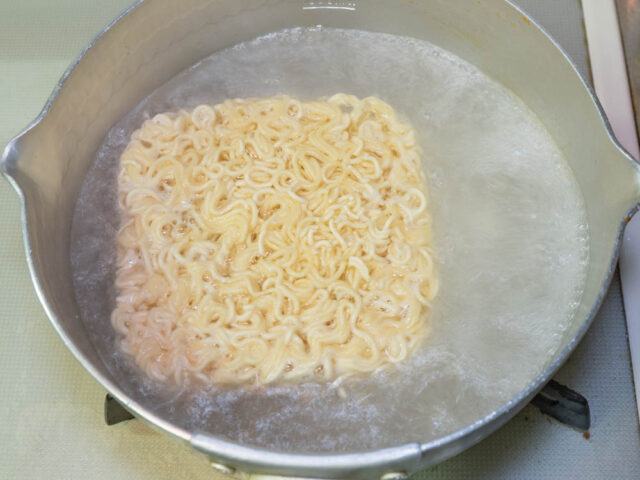 鍋にお湯を沸かしてインスタント麺を入れた写真