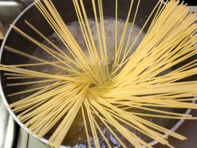 鍋にお湯を沸かしてパスタを入れた写真