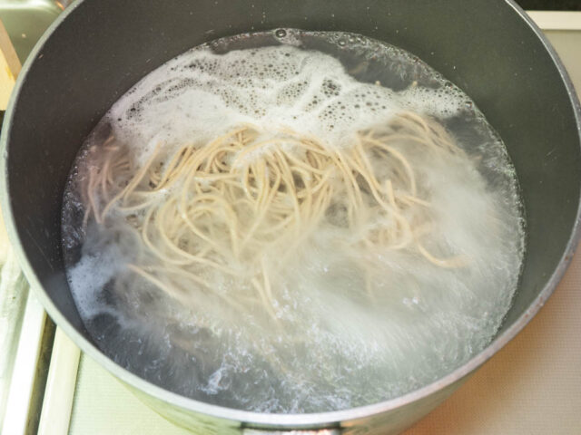 鍋にお湯を沸かして蕎麦を入れた写真