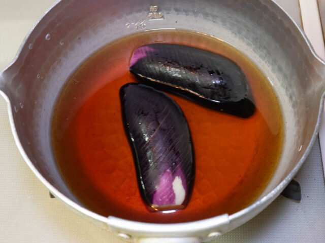 鍋に茄子とめんつゆ、水を入れて火をつけた写真