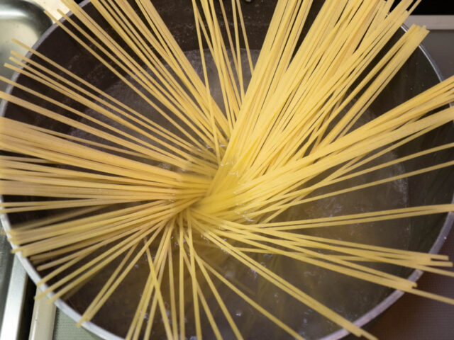 鍋にお湯を沸かしてパスタを入れた写真