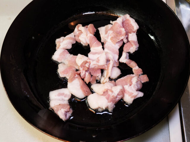 フライパンにサラダ油を熱して、豚バラ肉を入れた写真