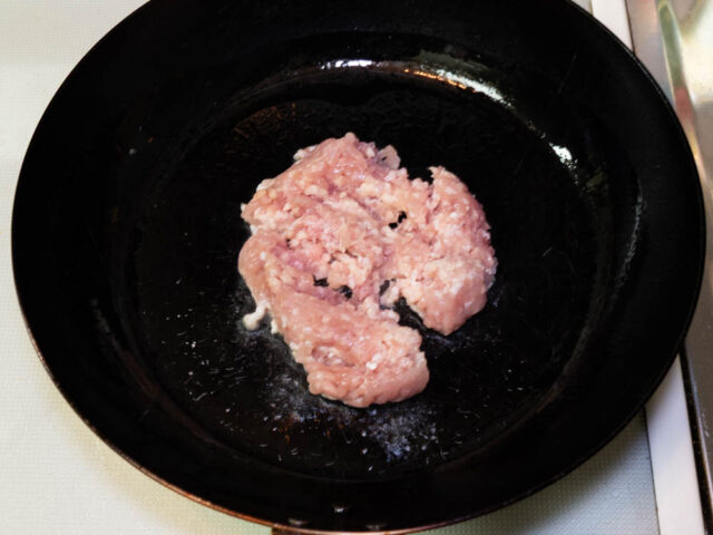 フライパンにサラダ油を熱して、鶏挽肉を加えた写真」
