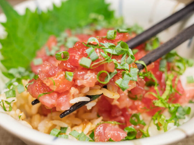 マグロのたたき丼を箸で持ち上げた写真