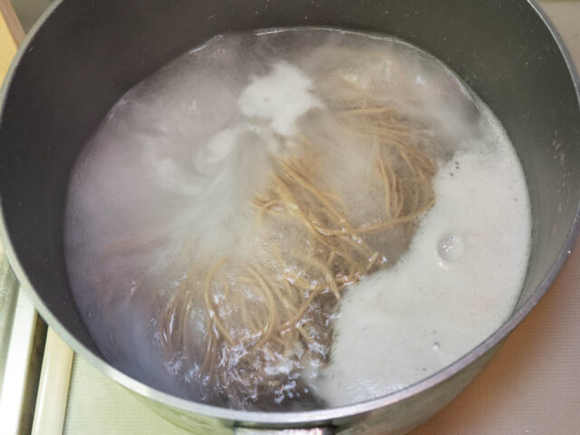 鍋にお湯を沸かし、蕎麦を茹でる写真