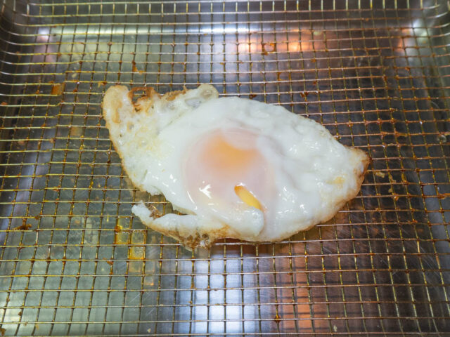 目玉焼きをザルに取り出した写真