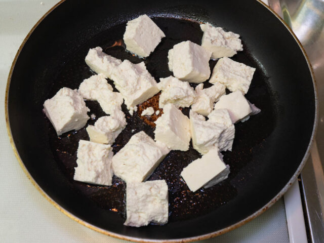 フライパンにサラダ油を熱して、ちぎった豆腐を並べ入れた写真