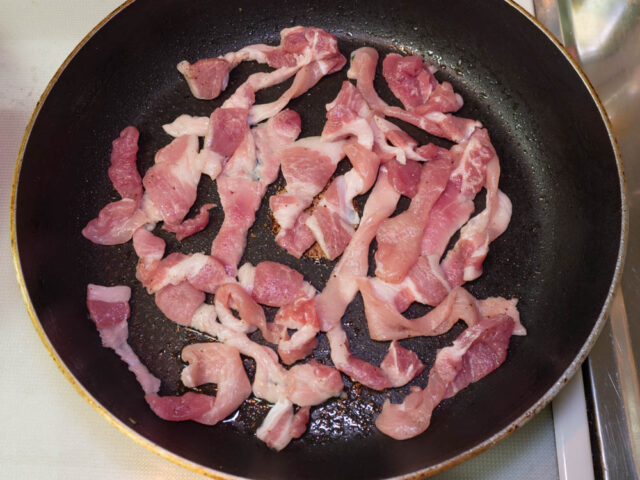 フライパンにサラダ油を熱して、豚肉を並べて入れた写真