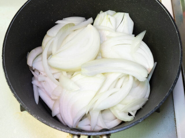 鍋にサラダ油を熱して玉ねぎを入れた写真