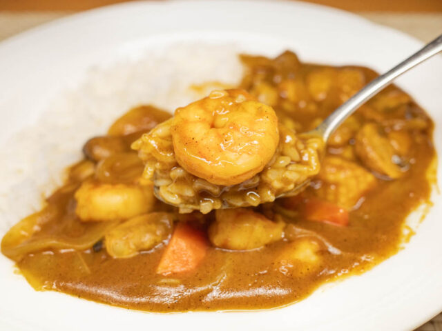 エビとカレーライスをスプーンにのせた写真