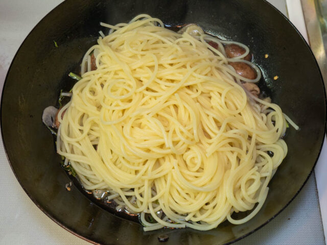 茹で上がったパスタをソースのフライパンに合わせた写真