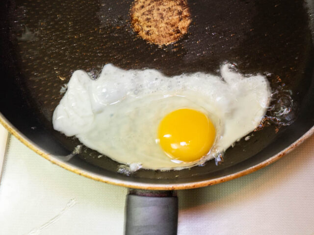 多めのサラダ油で目玉焼きをつくる写真