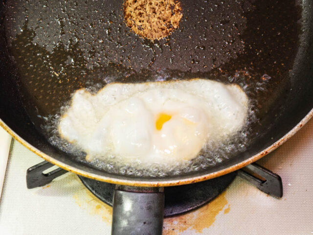 多めのサラダ油で目玉焼きをつくる写真