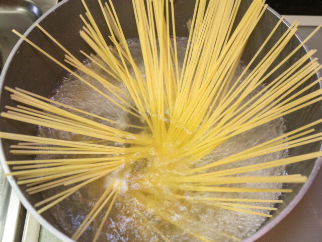 鍋にお湯を沸かし、塩を適量溶かしてからパスタを入れた写真