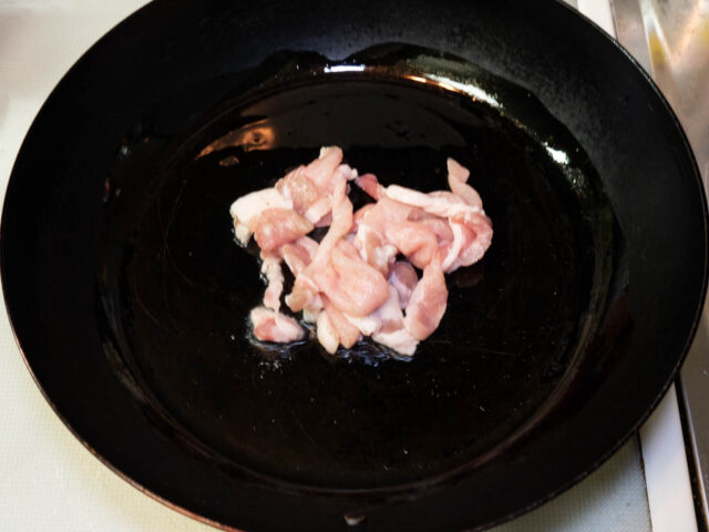 フライパンにサラダ油を熱して、豚肉を加えた写真