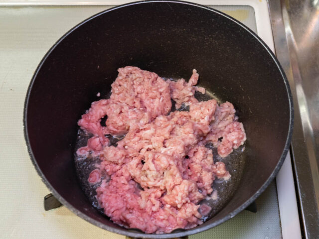 鍋にサラダ油を熱して豚挽肉を加えた写真