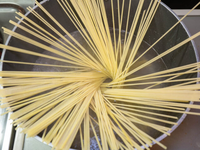 鍋にお湯沸かしてパスタを入れた写真