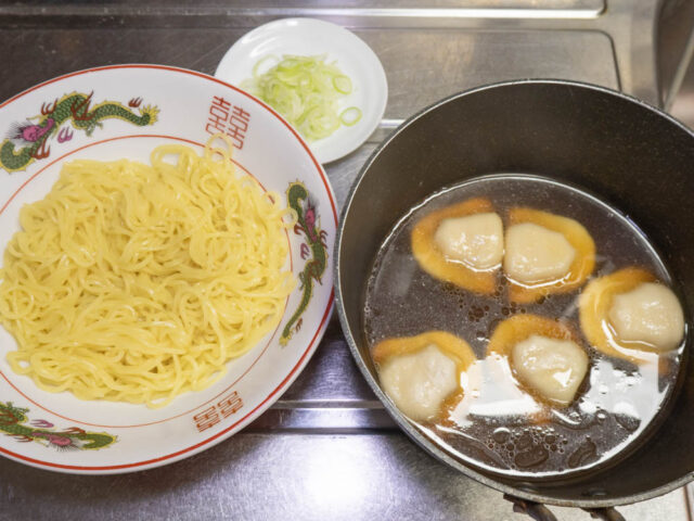 丼に入れた麺、スープと餃子、小口切りにした長ねぎの写真