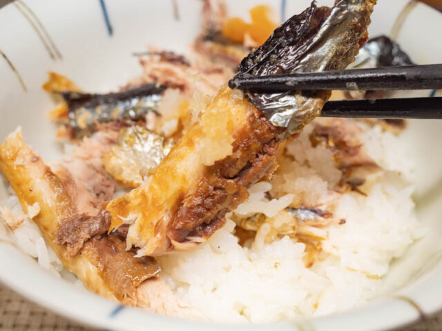 焼き秋刀魚を箸で持ち上げた写真