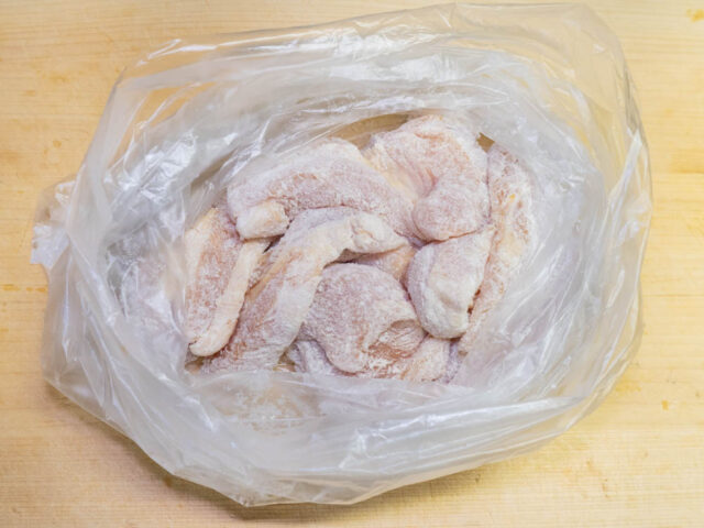 ビニール袋に豚肉と片栗粉を入れて振り、衣をつけた写真