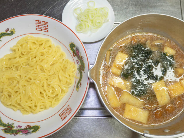 丼に入れた麺と、スープ、長ねぎの写真