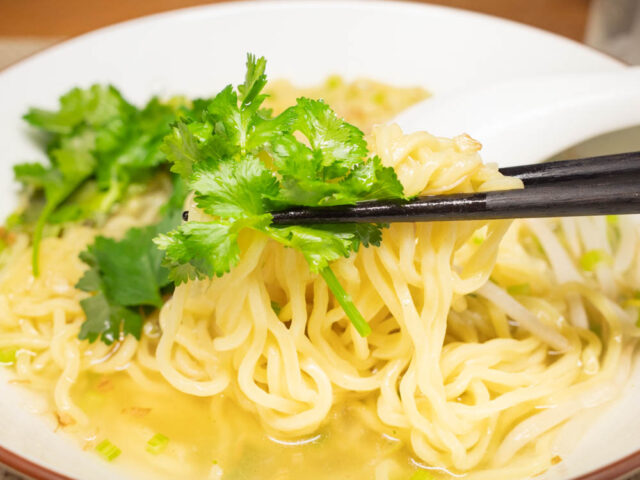 麺とパクチーを箸で持ち上げた写真