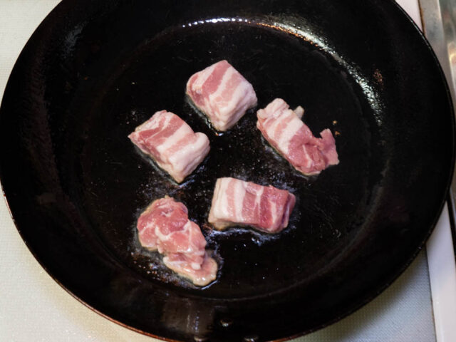 フライパンにサラダ油を熱して、豚肉を入れた写真