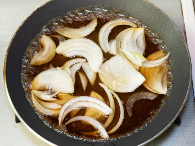 フライパンに水、めんつゆ、玉ねぎを入れて火をつけた写真