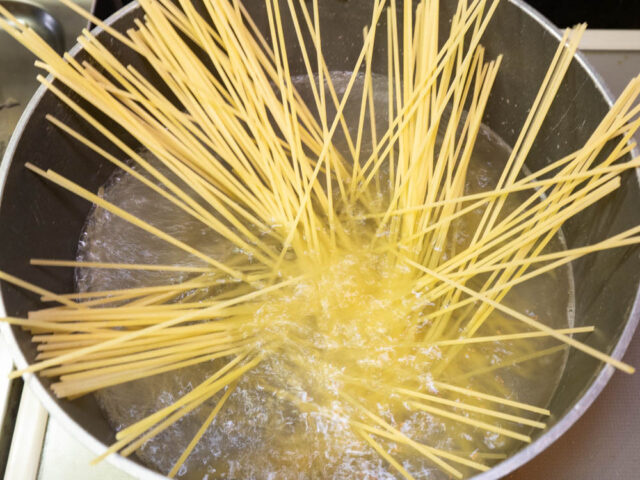 鍋にお湯を沸かし、塩を適量溶かしてからパスタを入れた写真