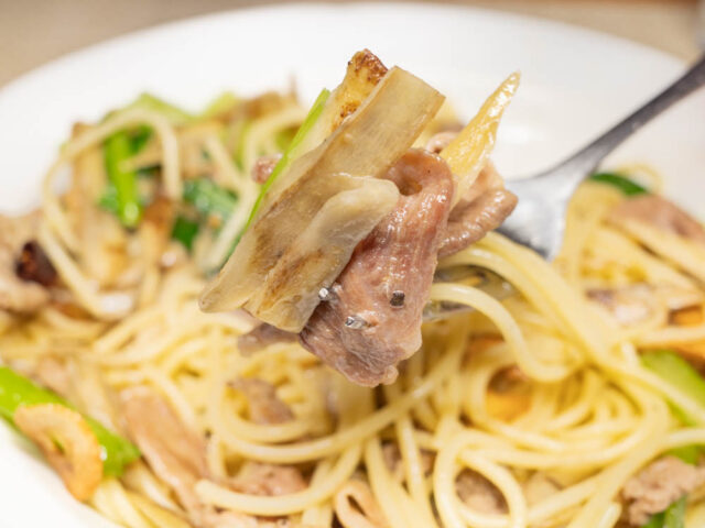 豚肉、ごぼう、小松菜をフォークで持ち上げた写真