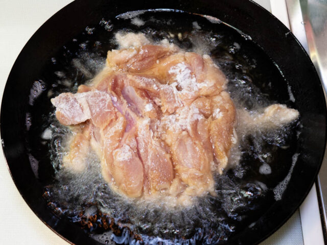 油に衣をつけた鶏肉を入れた写真