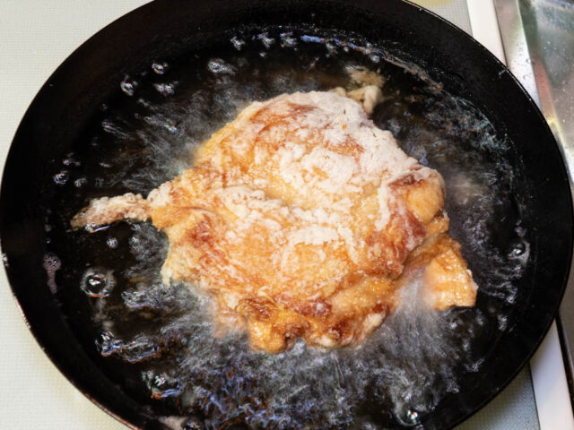 油の中で鶏肉をひっくり返した写真