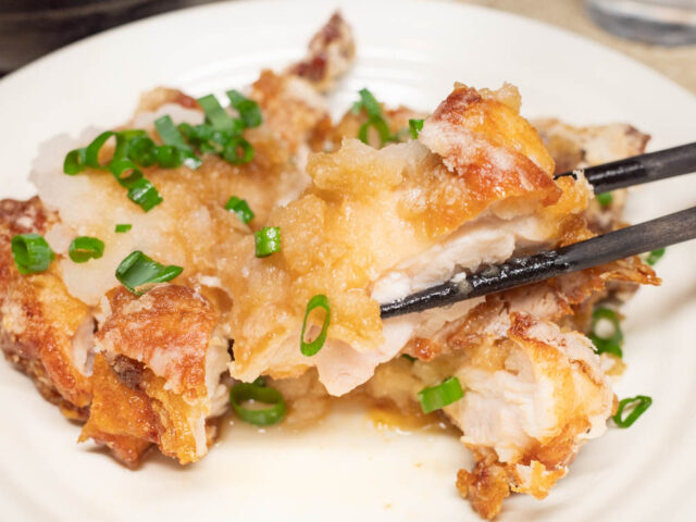 竜田揚げを箸で持ち上げた写真