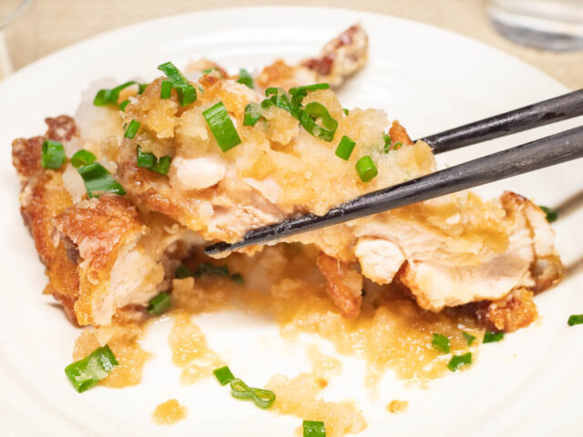 竜田揚げを箸で持ち上げた写真