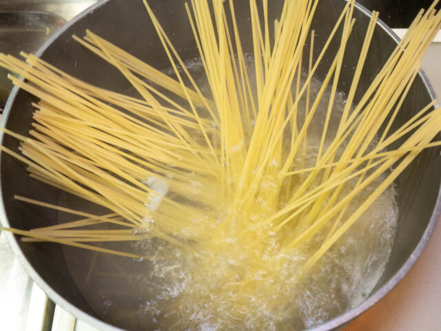鍋にお湯を沸かし、塩を適量溶かしてからパスタを入れた写真