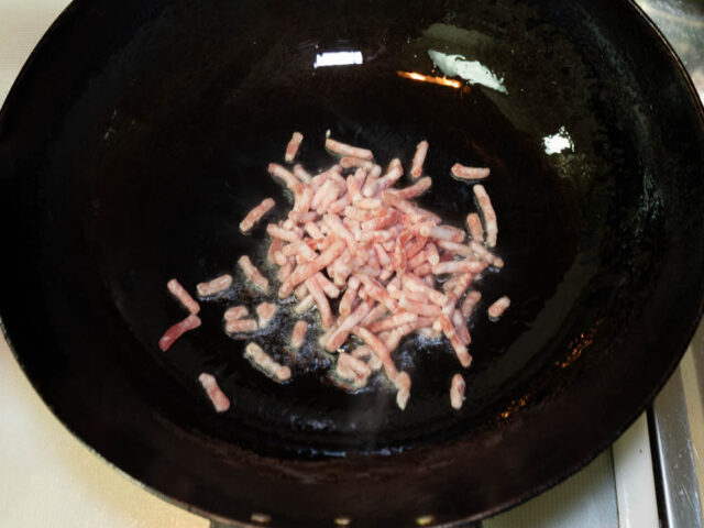 中華鍋にサラダ油を熱して、豚ひき肉を炒める写真