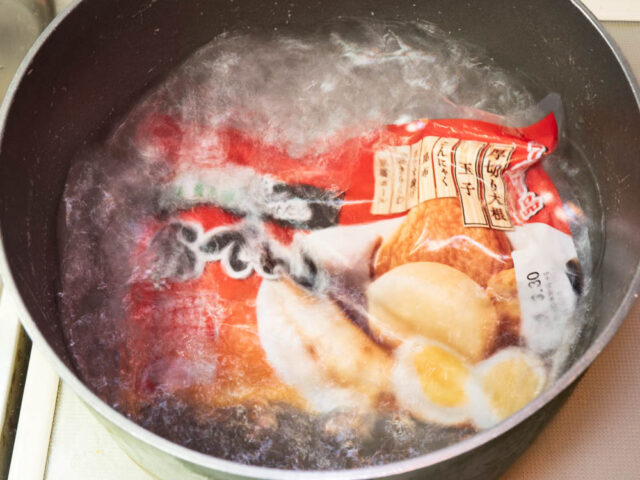 鍋にお湯を沸かし、レトルトおでんを温める写真