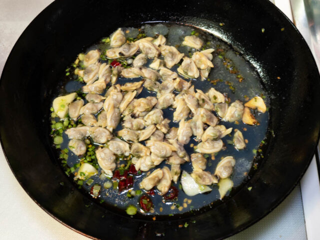 フライパンにアサリの水煮缶を加えた写真