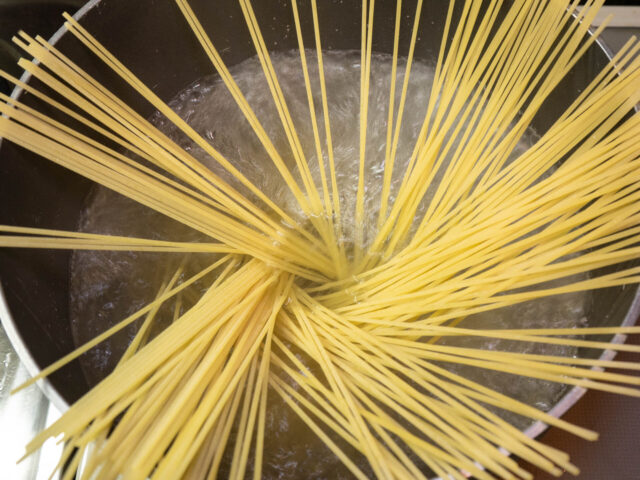 鍋にお湯を沸かしてパスタを入れた写真