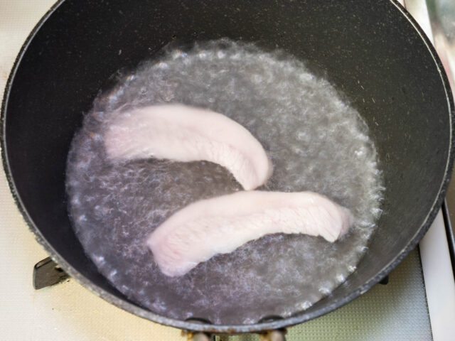 鍋にお湯を沸かし、豚トロを茹でる写真